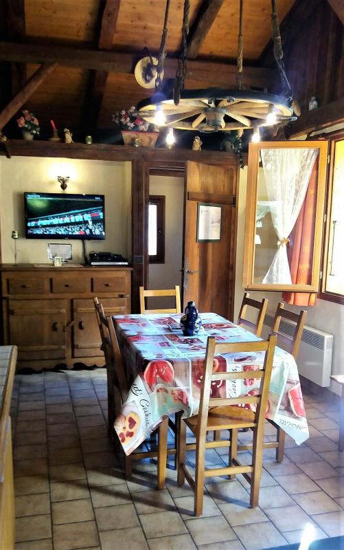 Escalier pour monter &agrave; la 3&egrave;me chambre, coin TV, porte donnant sur couloir qui va sur la terrasse, table pour repas