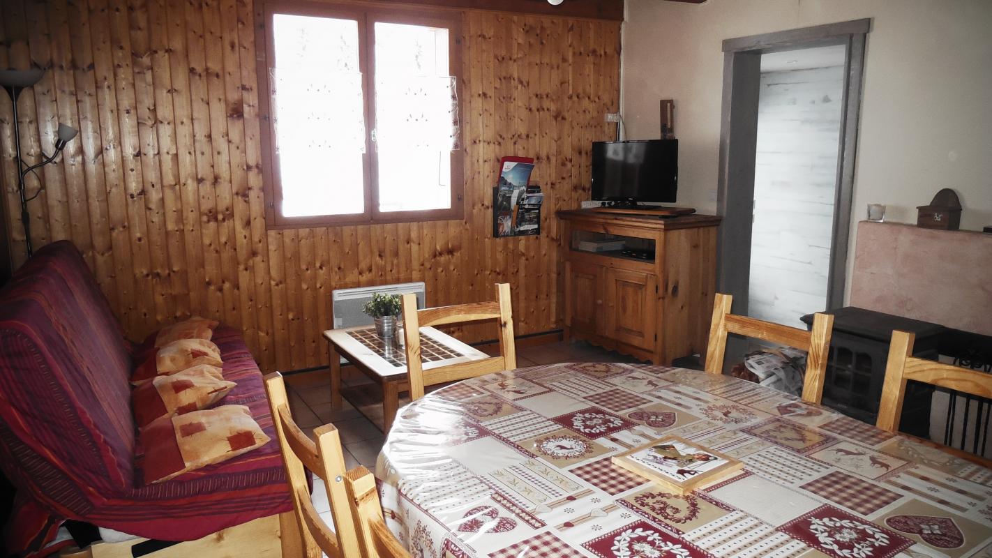 Coin salon avec tv, fourneau &agrave; bois.