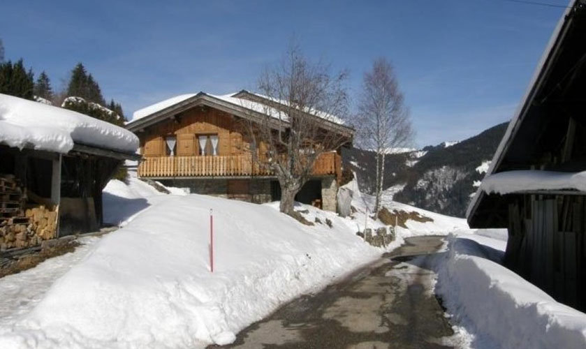 En hiver les voitures sont &agrave; l'abris sous le toit du petit b&acirc;timent sur la gauche. Le g&icirc;te est en clair dans le fond. A droite ferme typiquement savoyarde o&ugrave; habitent les propri&eacute;taires.